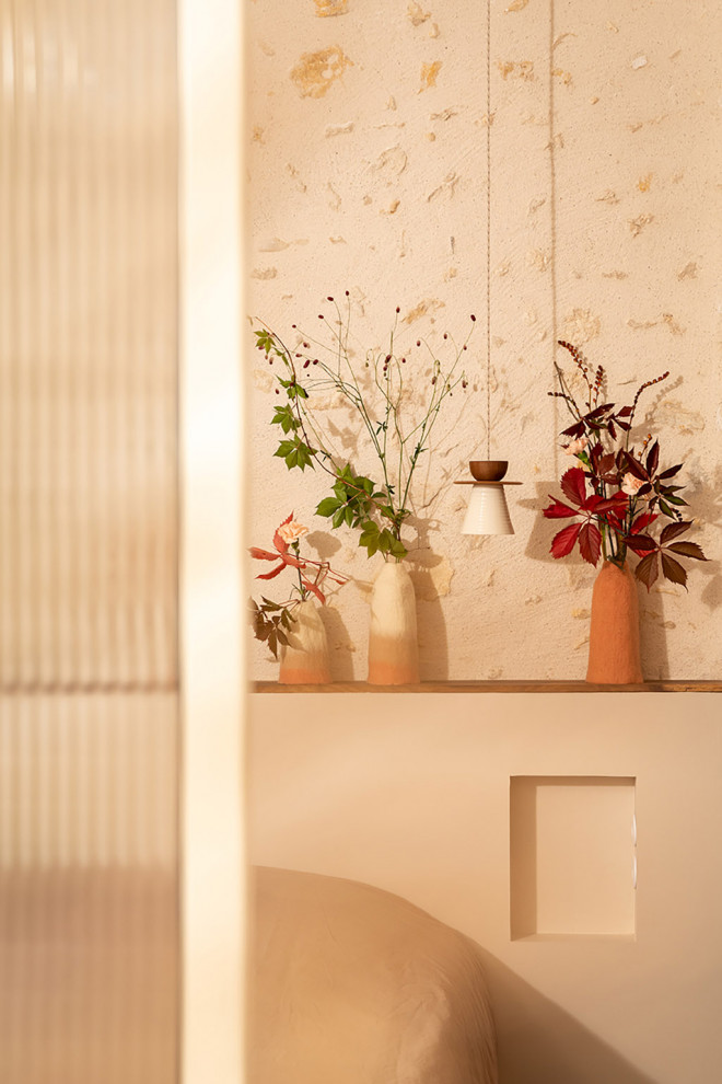 Duo of colorful boiled wool vases placed on a wooden bench