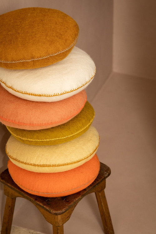 Stack of felted cushions on a stool
