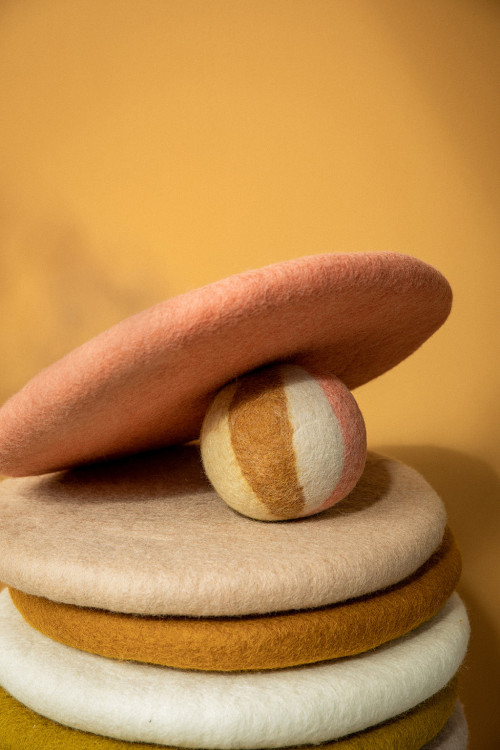 stack of colored felt cushions and multicolored ball