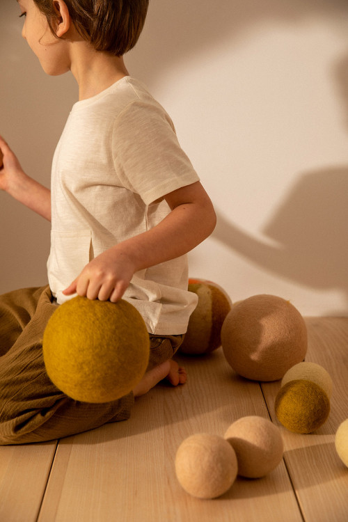 a child plays with the colored felt balls