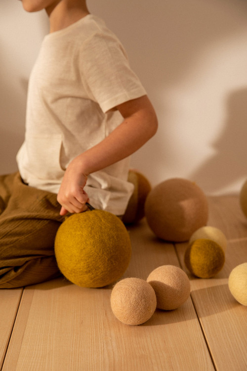 a child plays with his colored felt balls