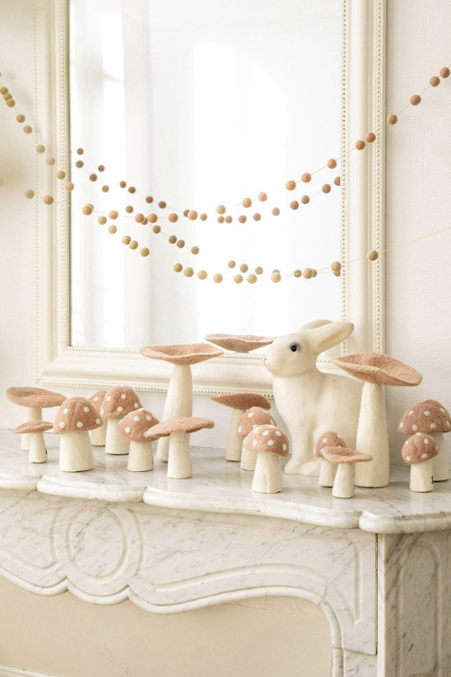 des champignons en feutre sur le bord d'une cheminée apporte une touche poétique à la décoration