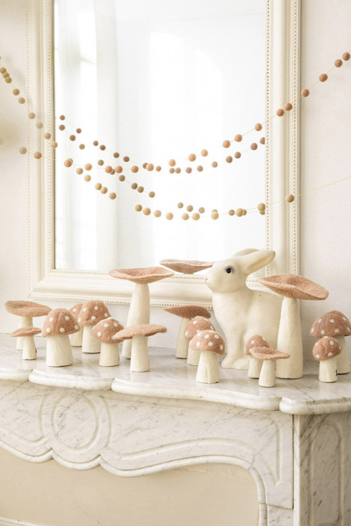 Felt mushrooms on the edge of a fireplace brings a poetic touch to the decoration