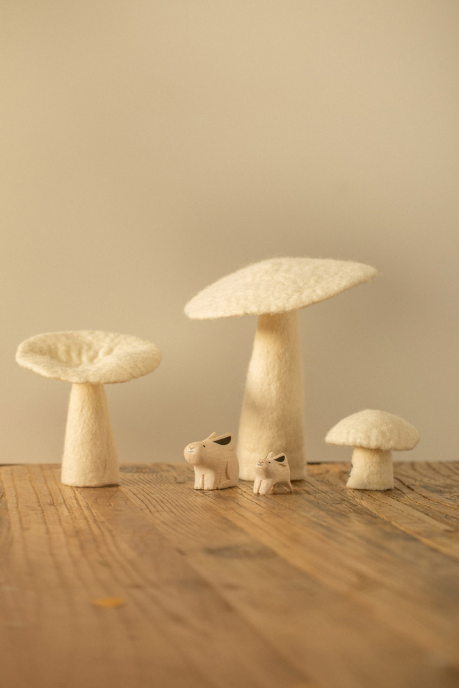 Woolen mushrooms on a wooden table as a decorative object