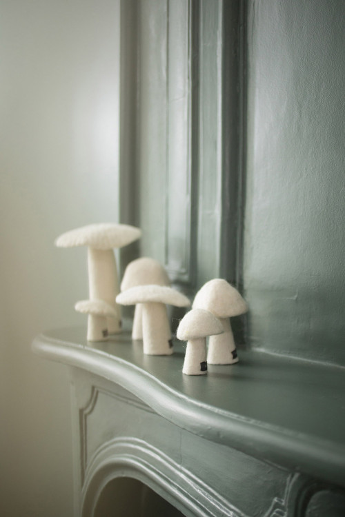 des champignons blancs en feutre pour décorer le rebord d'une cheminée