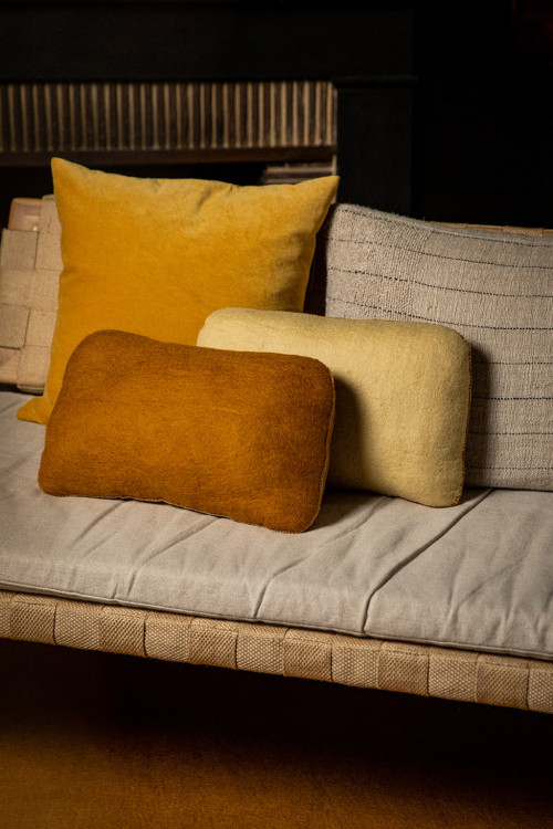 Trio of matching felt cushions on a bench