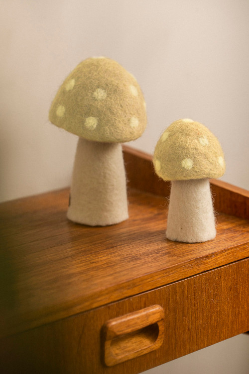 deux champignons à pois jaune clair en laine feutrée pour apporter une touche de couleur à sa décoration
