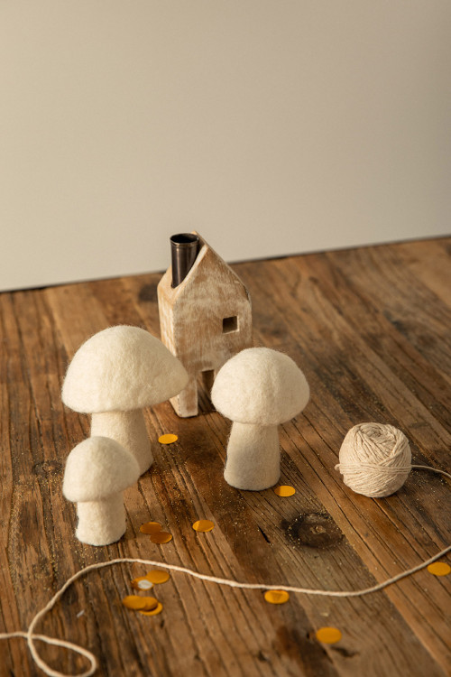 petits champignons blancs en feutre décorent une table pour une atmosphère poétique petits champignons blancs en feutre décorent une table pour une atmosphère poétique