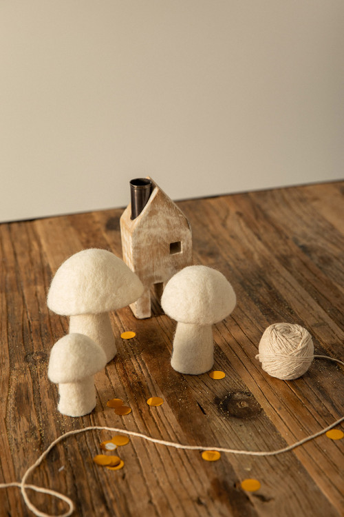 small white felt mushrooms decorate a table for a poetic atmosphere