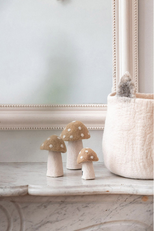 three pink polka dot felted mushrooms placed next to a felt basket with fox ears