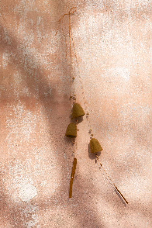 three small green bells in felted wool let themselves be carried by the wind in a light way