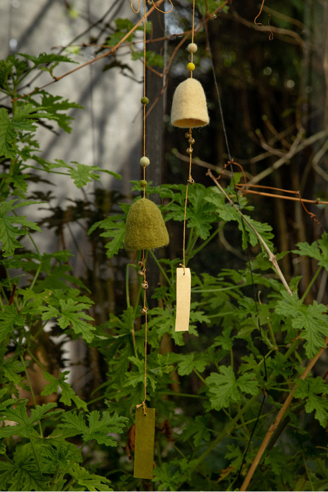 deux cloches en feutre suspendues à la poignées d'une porte pour un décoration poétique et colorée