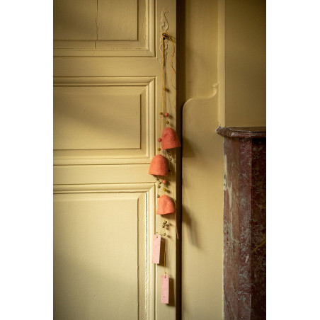 deux cloches en feutre suspendues à la poignées d'une porte pour un décoration poétique et colorée