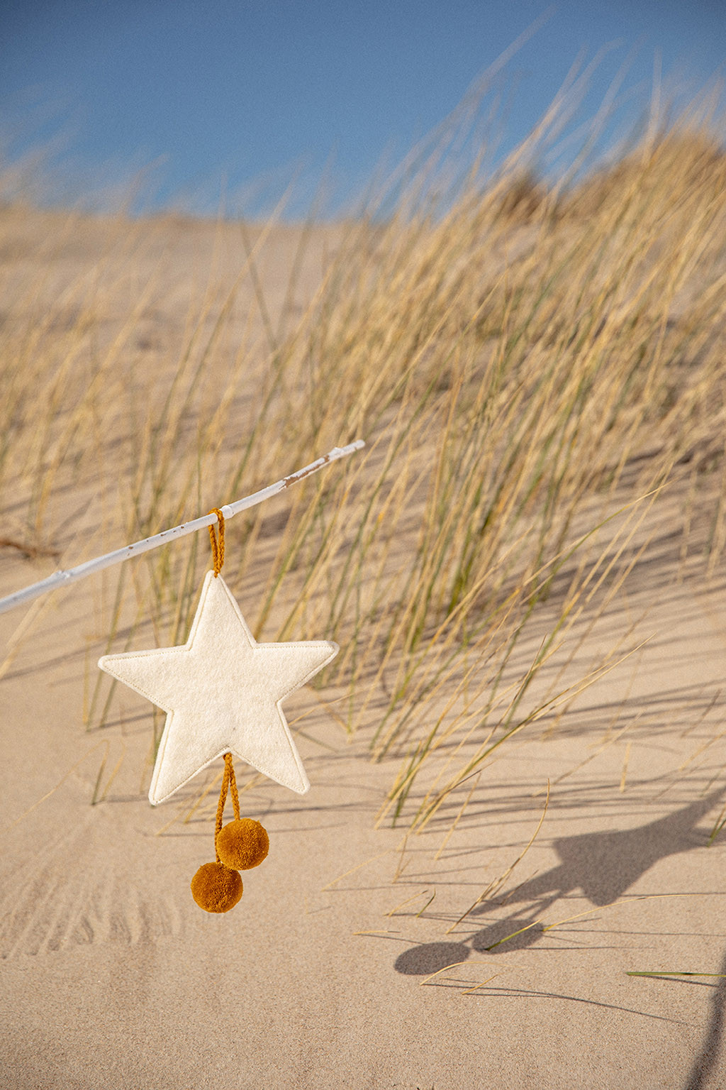 a white felt star with pollen pompons for a natural touch