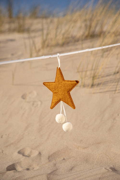 a gold felt star with white pompons for a colorful touch