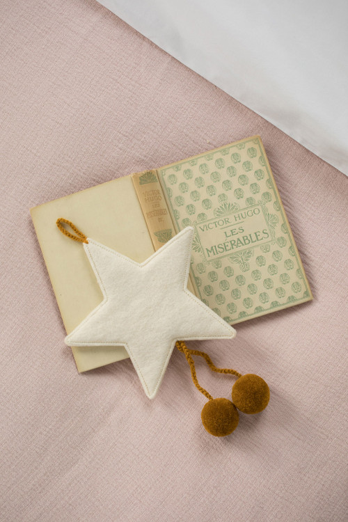 a white pompom star made of hand felted wool for an elegant and soft decoration