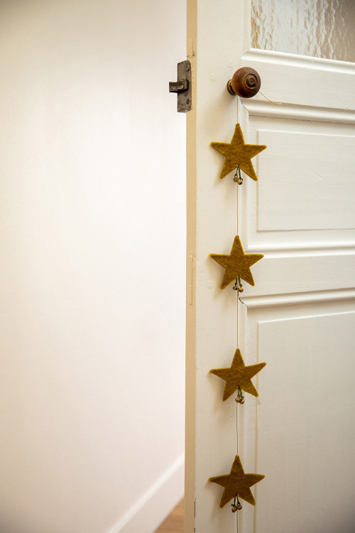 une guirlande d'étoiles suspendue à la poignée d'une porte pour une décoration poétique