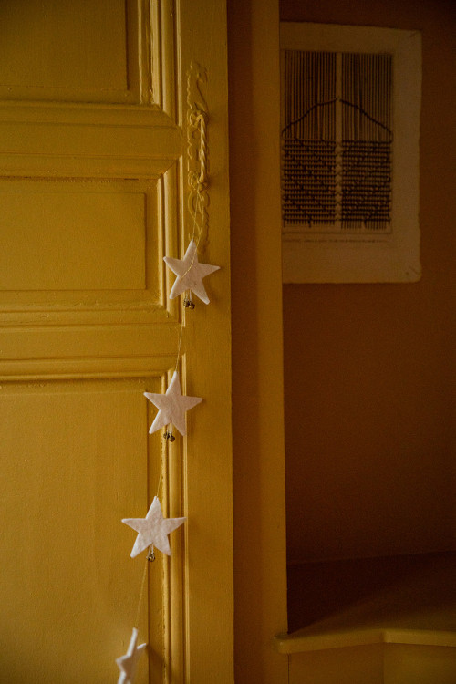 une guirlandes d'étoiles blanches en feutre se balance avec légèreté le long d'une porte