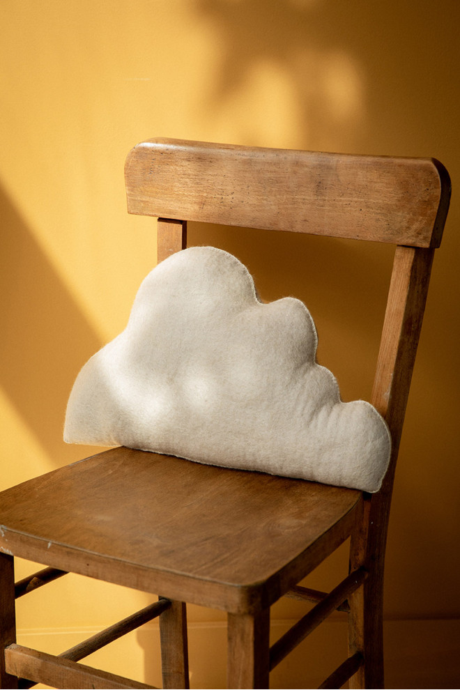 Coussins nuage naturel et or posés sur un canapé