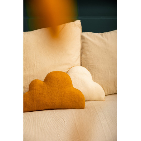 Coussins nuage naturel et or posés sur un canapé