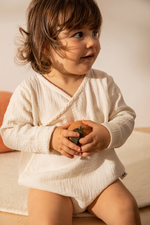 a child plays with a soft felt apricot