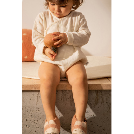 une enfant joue avec une pomme en feutre douce et moelleuse