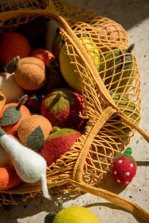 un sac filet rempli de fruits et légumes fabriqués en feutre