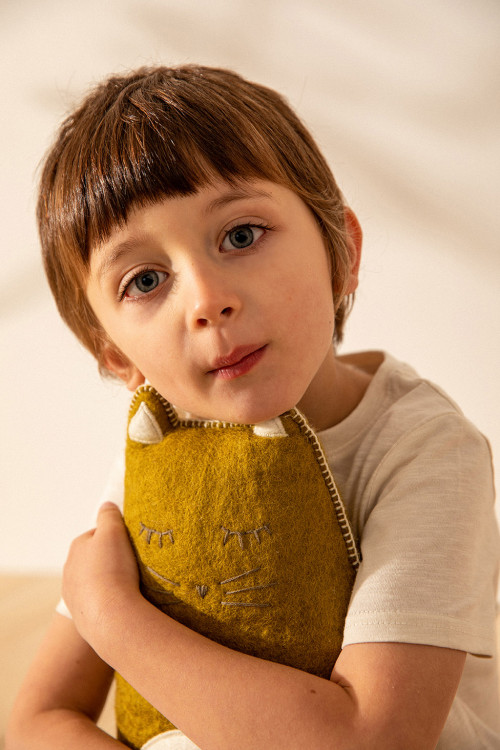 Un enfant et son coussin chat en laine