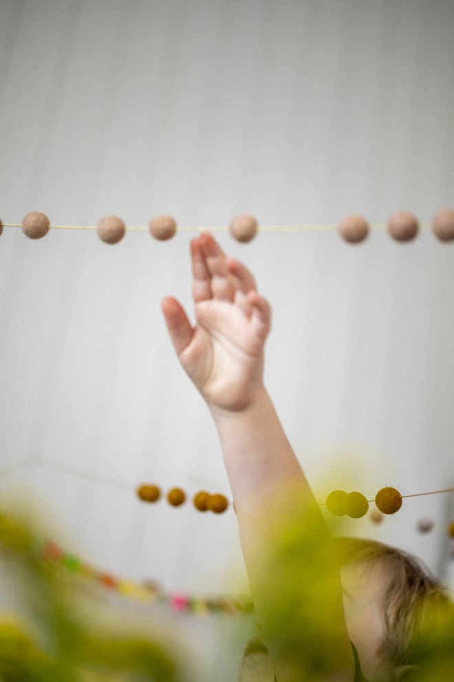 Felt pompons on a golden thread to create a playful garland