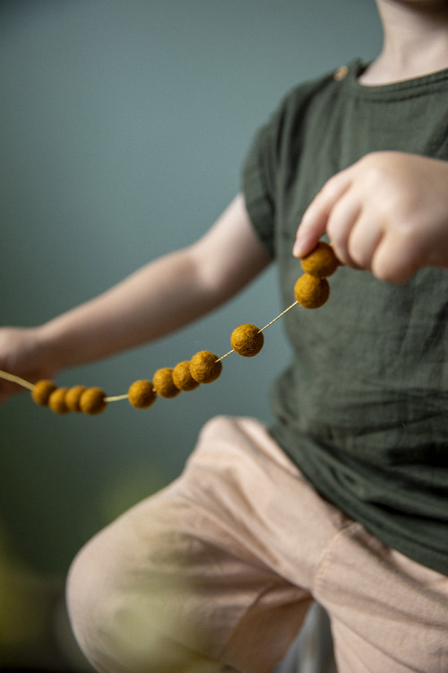 des pompons en feutre sur un fil doré pour créer un guirlande ludique des pompons en feutre sur un fil doré pour créer un guirlande ludique