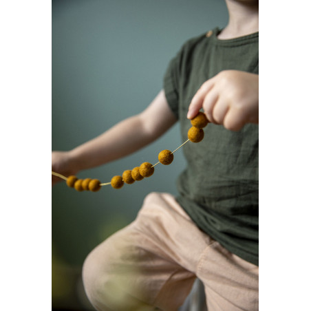 Felt pompons on a golden thread to create a playful garland