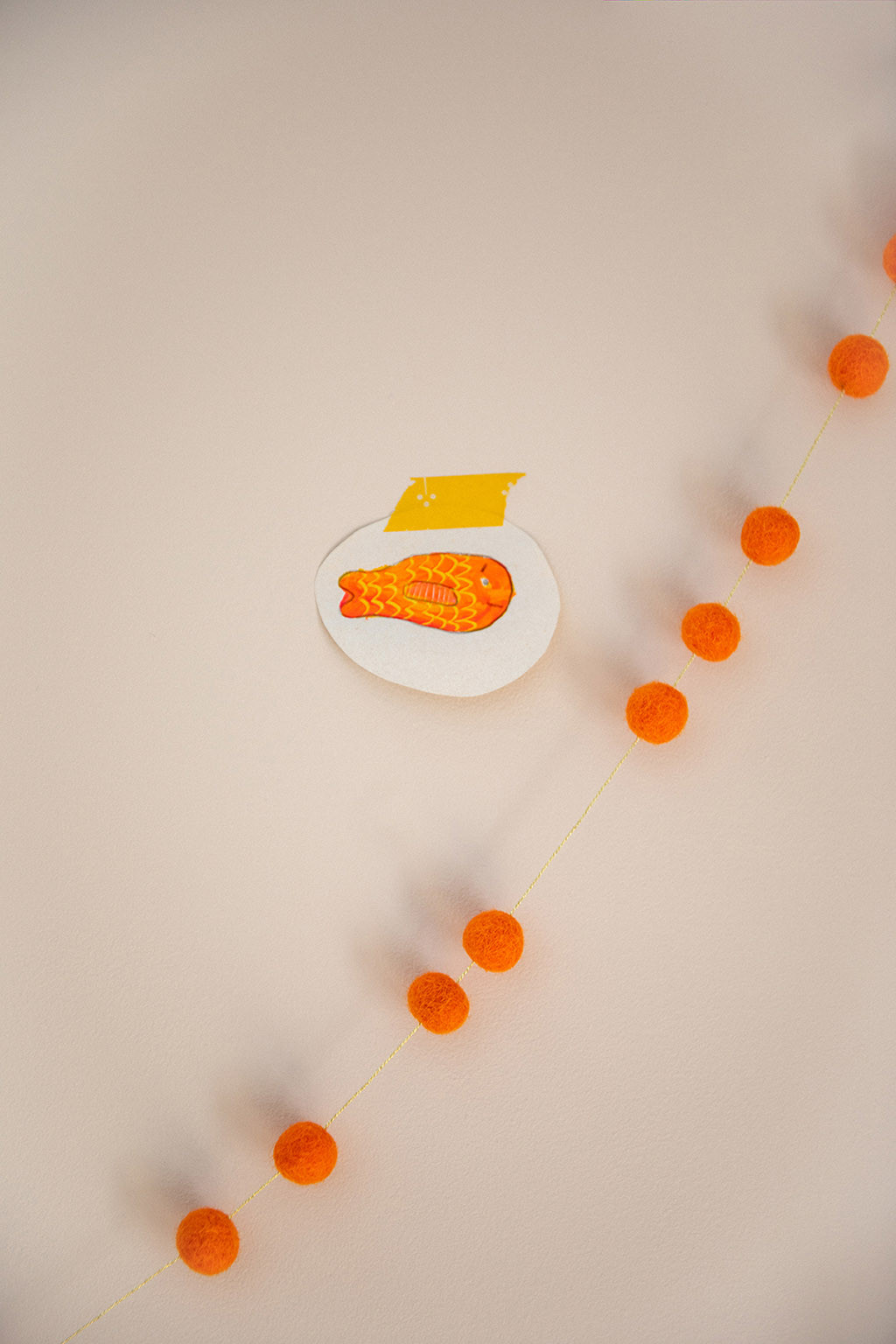a garland with orange felt pompons for a playful and joyful decoration