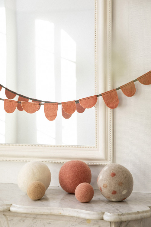 une guirlande rose accompagne des balles en feutre pour une décoration ludique une guirlande rose accompagne des balles en feutre pour une décoration ludique