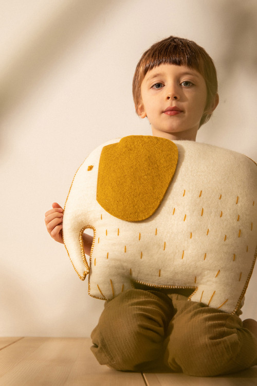 Un enfant et son coussin éléphant feutré Un enfant et son coussin éléphant feutré