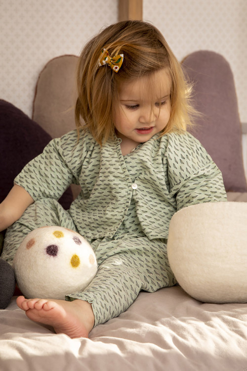 a child playing with a handmade felt ball a child playing with a handmade felt ball