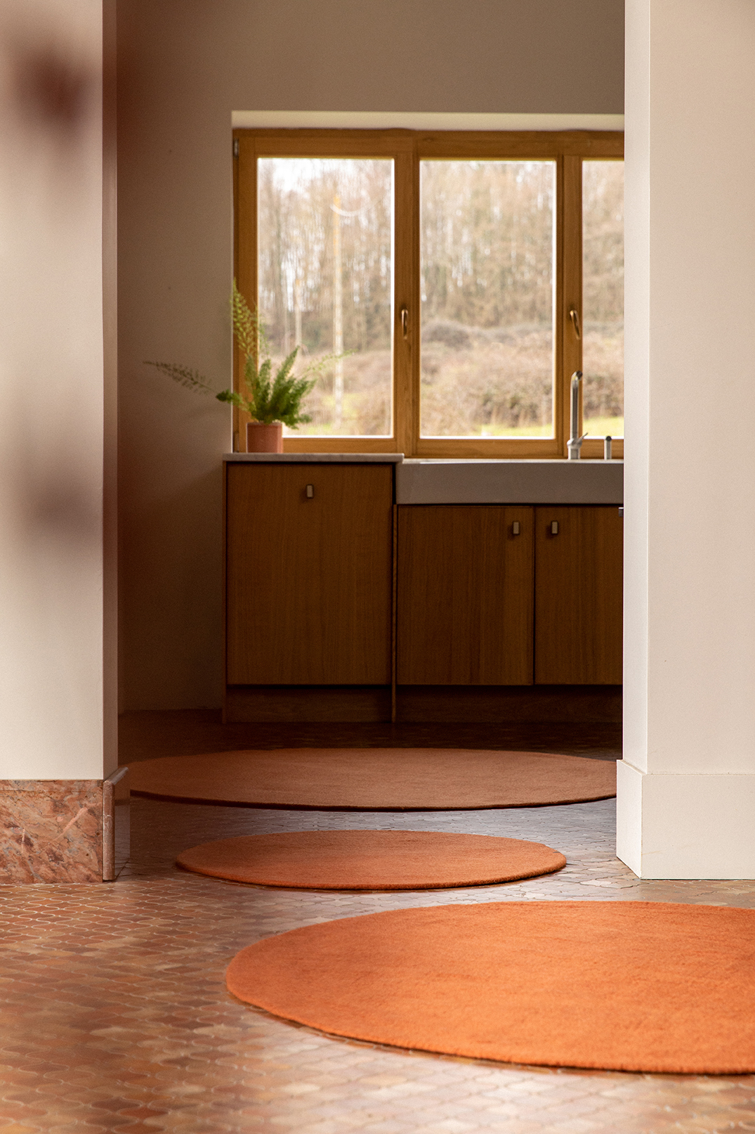Trio de petits tapis ronds terracotta pour réchauffer l'atmosphère dans un couloir