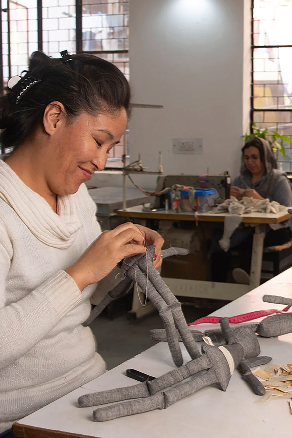 Femme en train de coudre une poupée Silaiwali