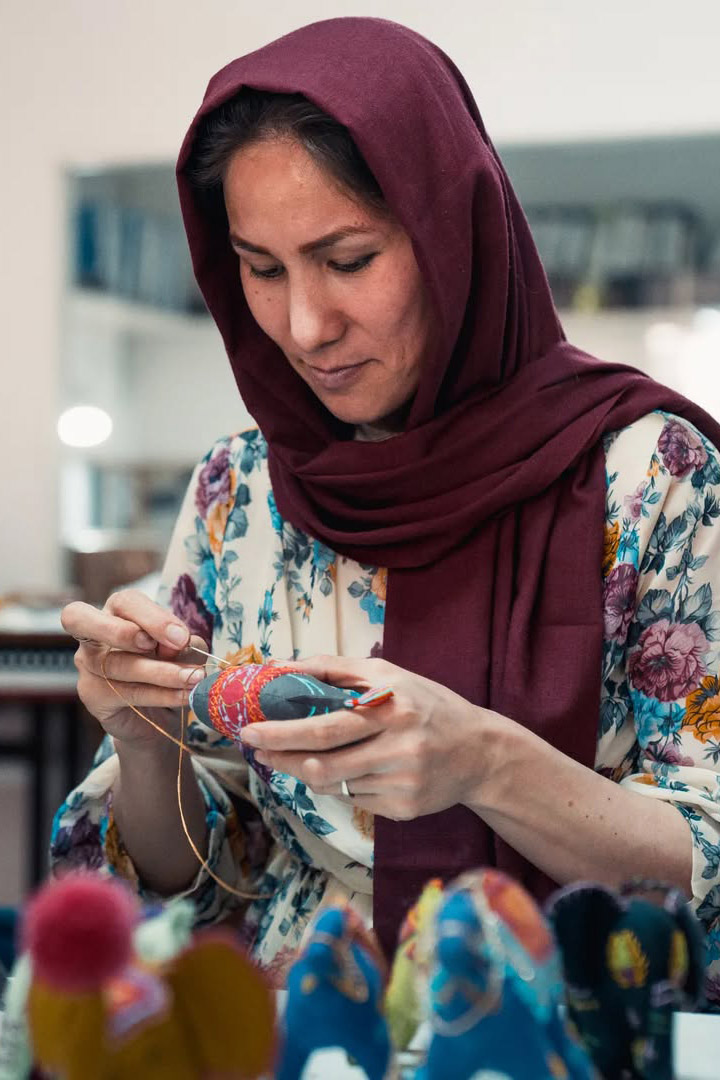 Artisanae afghane en train de coudre une poupée pour enfant