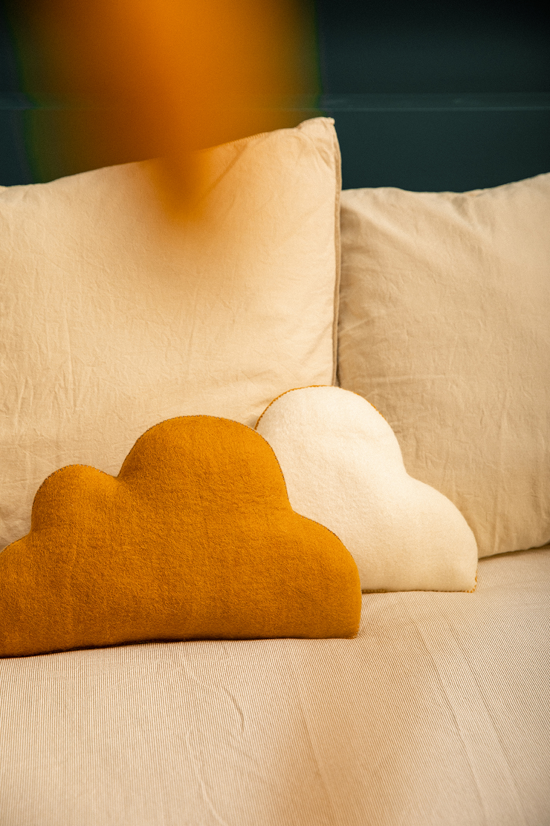 Duo de coussins en forme de nuage en laine feutrée jaune et blanc poés en tête de lit pour une décoration ludique de la chambre