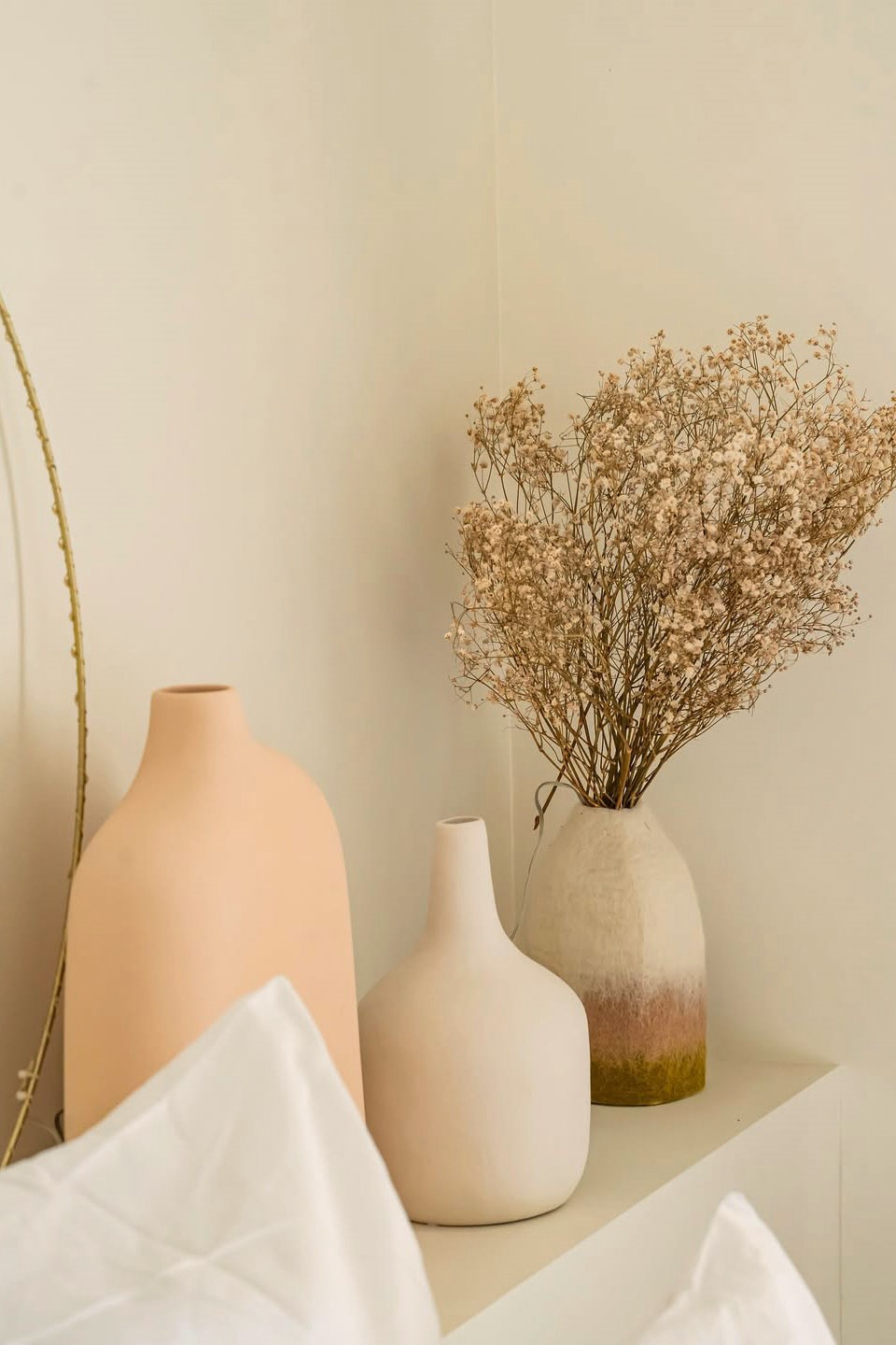 Assortiment de vases en laine feutrée et céramique pour décorer le rebord de la tête de lit