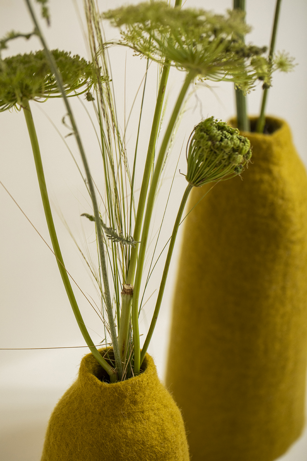 Focus matière sur un vase vert en laine feutrée