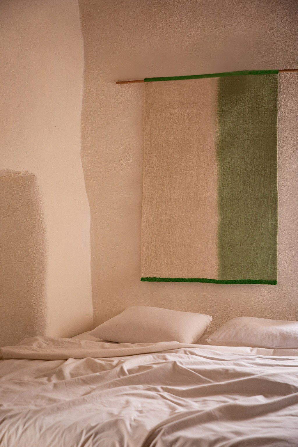 Tenture murale verte en feutre pour orner la tête de lit dans une chambre