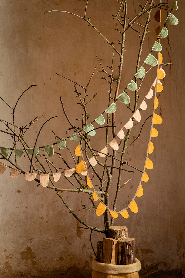 Guirlandes de drapeaux verte, jaune et rose en laine bouillie dans un arbre de Noël