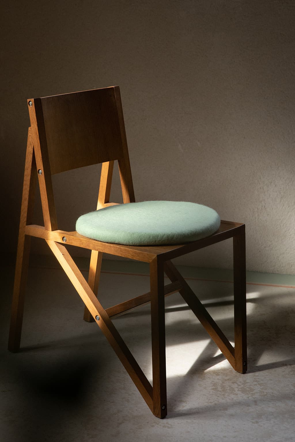 Galette de chaise en laine vert menthe sur une chaise en bois