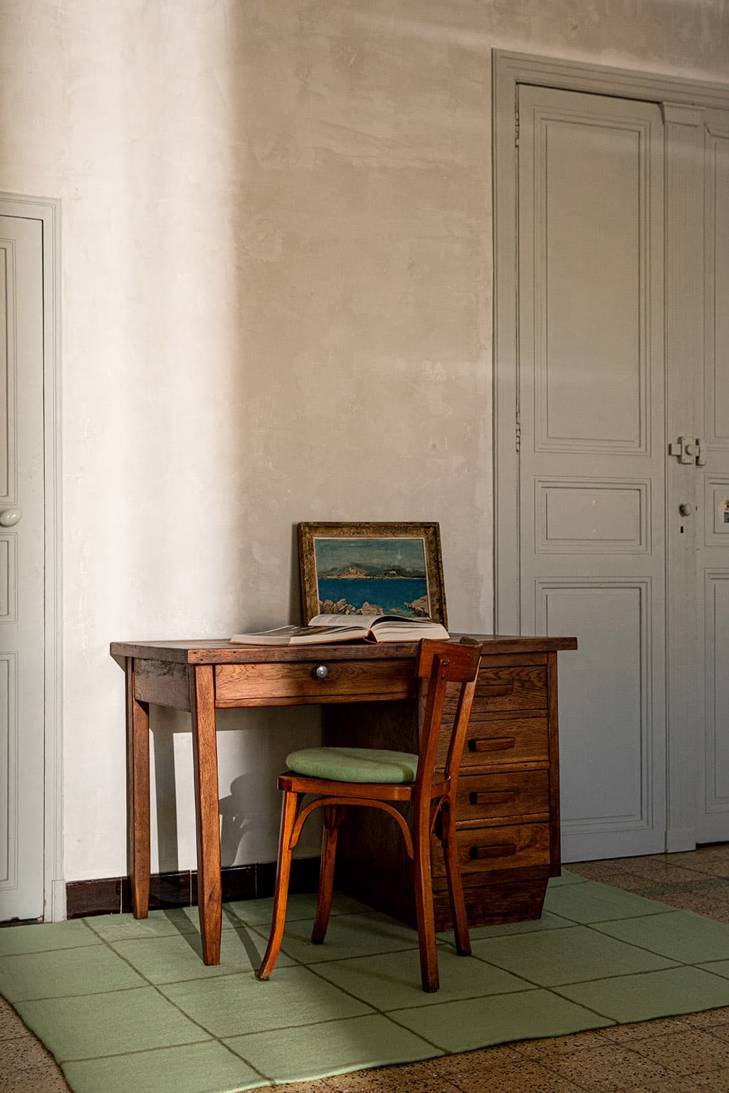 Tapis rectangulaire en laine à carreaux vert menthe sous un bureau en bois