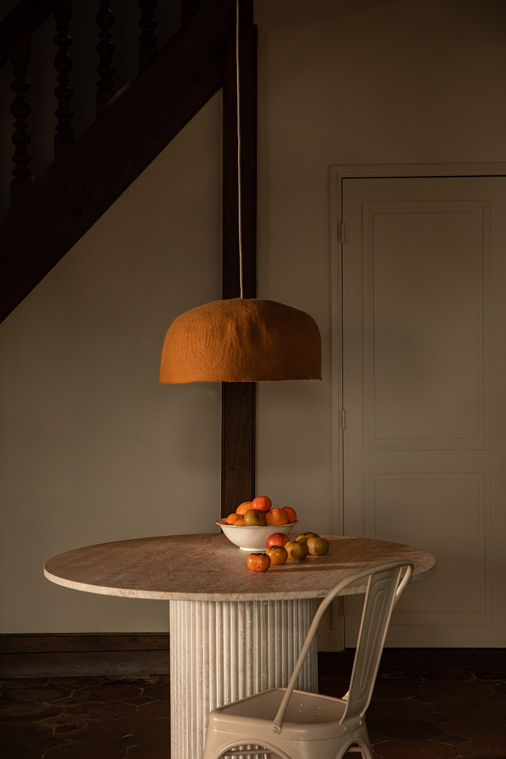 Abat-jour organique en feutre suspendu et table en marbre pour une décoration minimaliste et chaleureuse