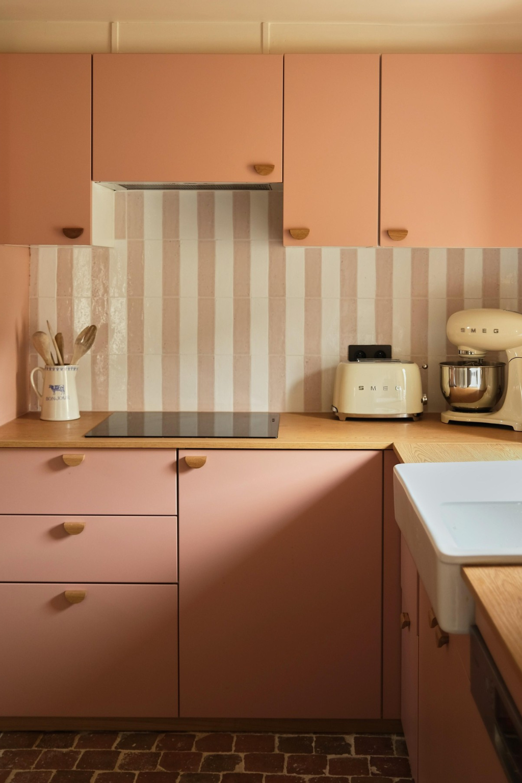 Une cuisine à rayures en bois clair et rose poudré