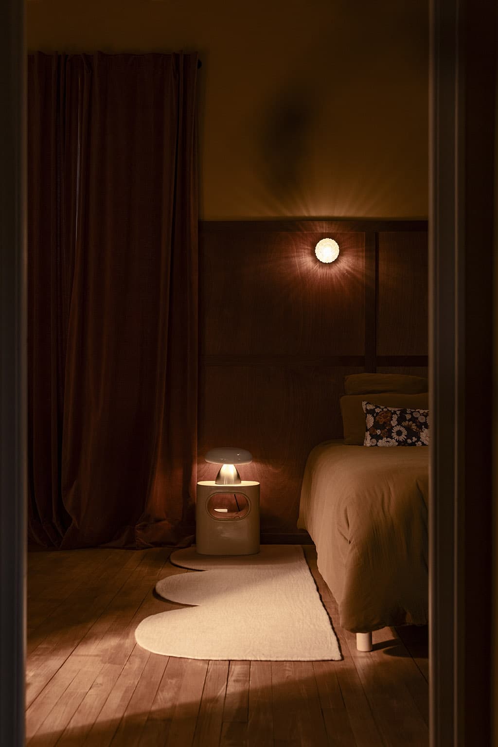 Parquet en bois foncé avec un tapis en laine rose poudré dans la chambre