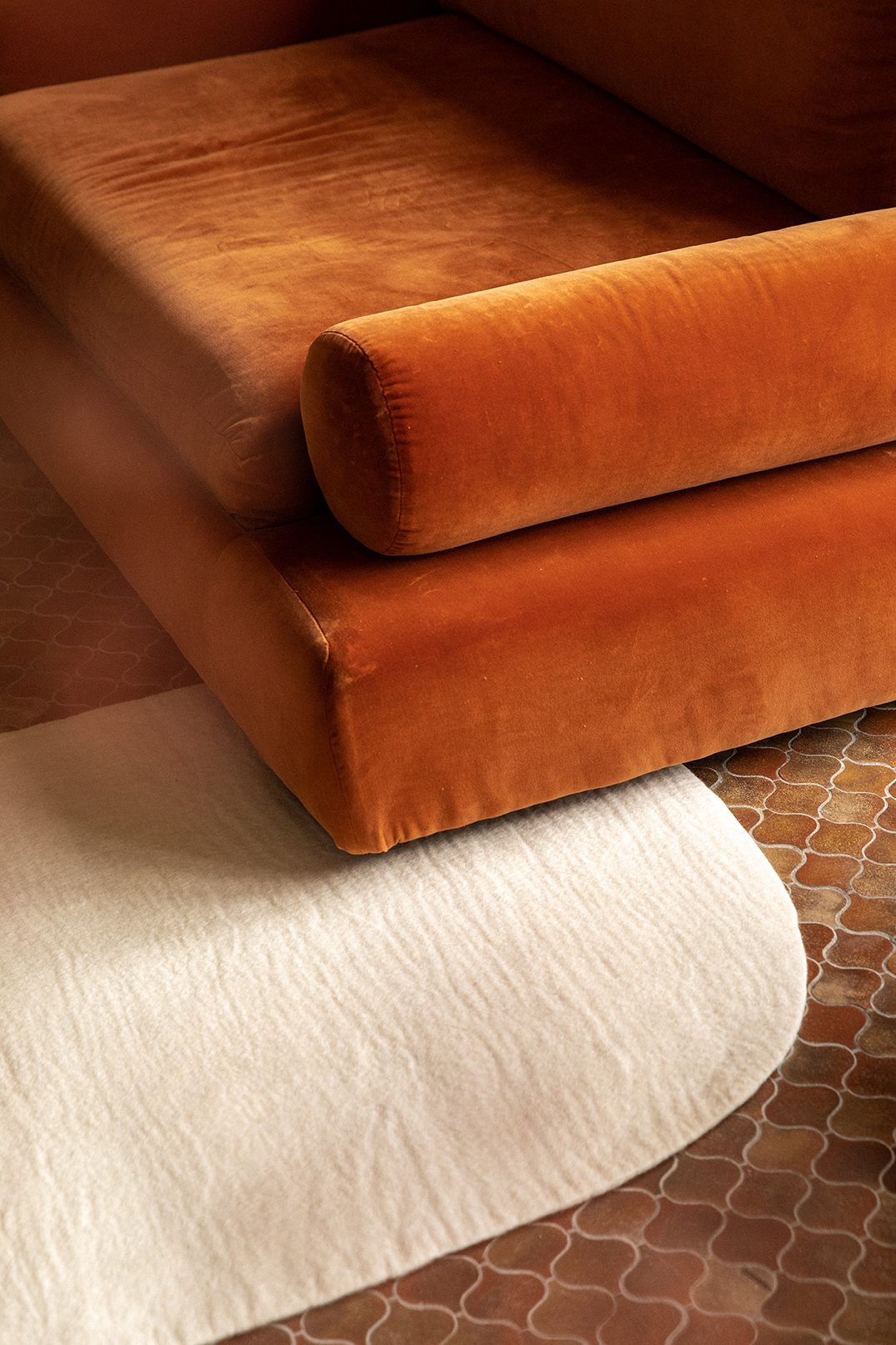 Canapé terracotta associé à un tapis blanc dans un salon