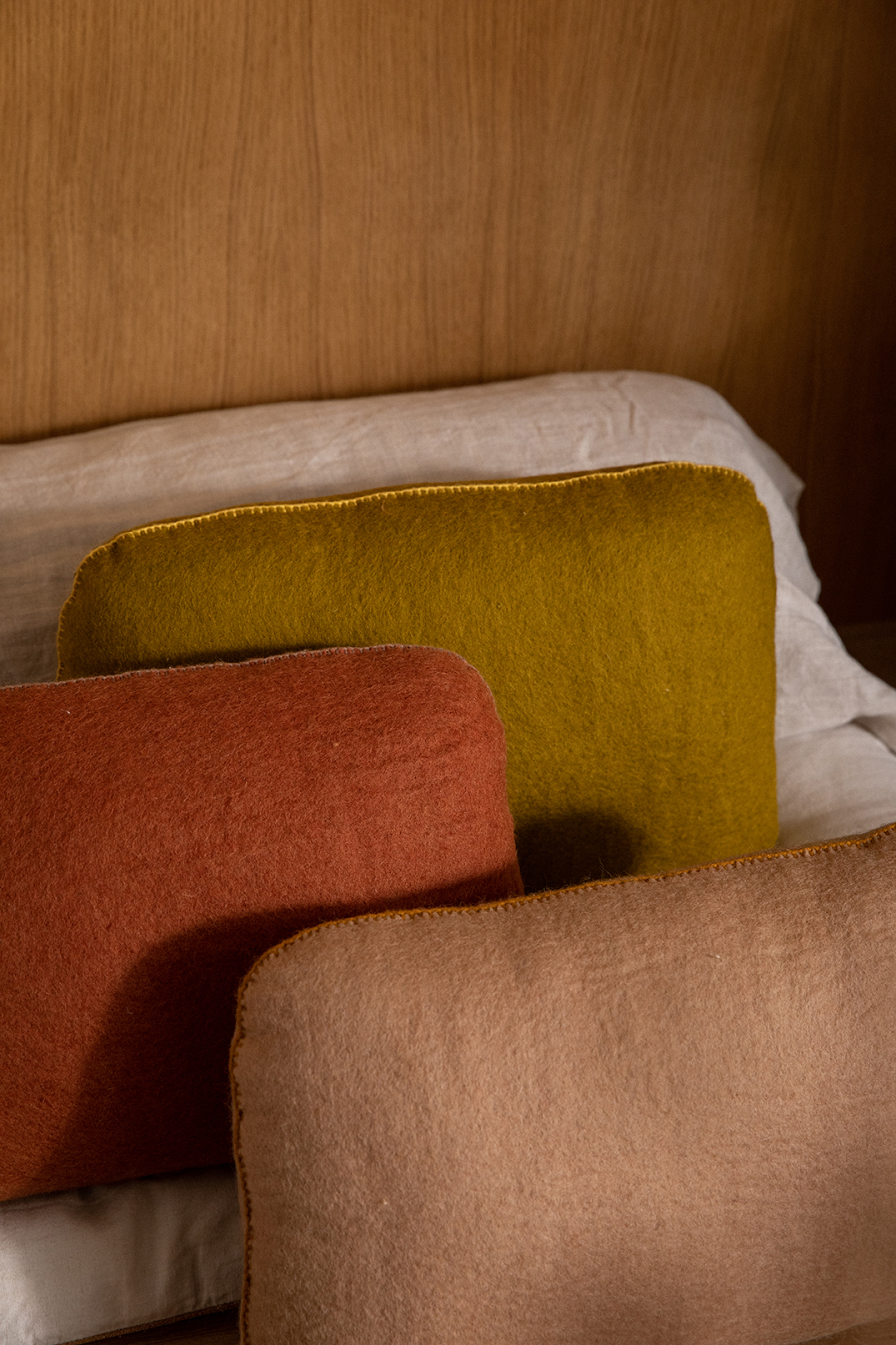 Trio de coussins en laine feutrée à disposer sur un canapé pour une décoration cocooning